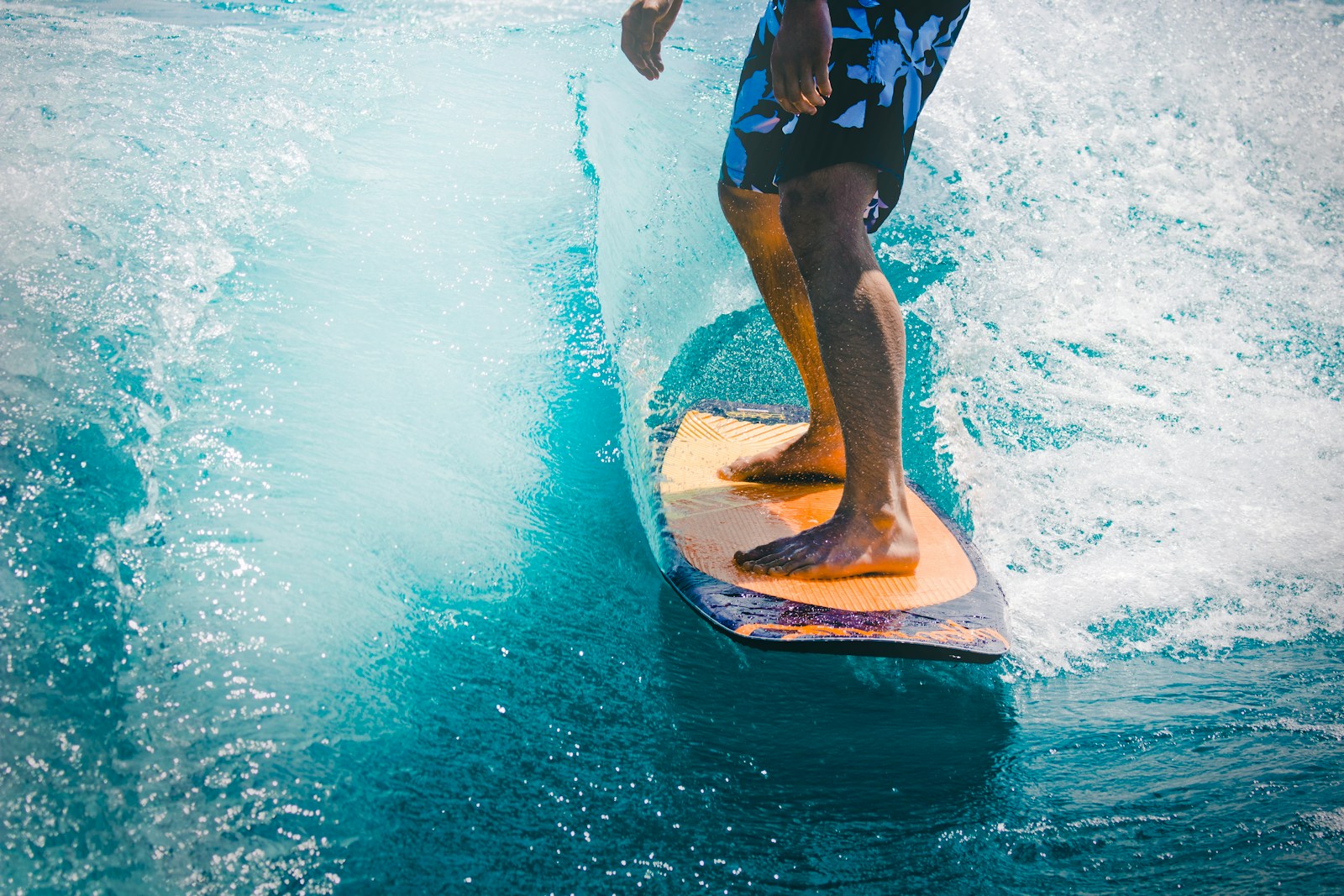 man riding wave with orange surfboard