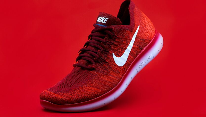 unpaired red Nike sneaker